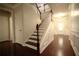 Entryway featuring dark wood floors, white wainscoting, and staircase with dark wood handrail at 1142 Terrasol Rdg, Lilburn, GA 30047