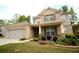 Charming two-story brick home featuring a manicured lawn, colorful flower beds, and inviting front porch at 1142 Terrasol Rdg, Lilburn, GA 30047