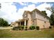 Brick home with professional landscaping featuring green lawn, bushes, and various flowers near the front porch at 1142 Terrasol Rdg, Lilburn, GA 30047