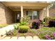 Inviting covered front porch featuring colorful flower beds and professional landscaping surrounding brick columns at 1142 Terrasol Rdg, Lilburn, GA 30047