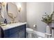 Chic powder room with stylish blue vanity, gold fixtures, and patterned floor tiles at 1188 Woodtrace Ln, Auburn, GA 30011