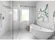 Modern bathroom featuring a soaking tub, glass-enclosed shower, and white marble tile at 1188 Woodtrace Ln, Auburn, GA 30011