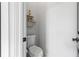 Simple half-bathroom featuring toilet and wall shelf, perfect for guest use at 1188 Woodtrace Ln, Auburn, GA 30011