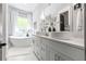 Modern bathroom featuring double sinks, a soaking tub, and elegant fixtures for a luxurious experience at 1188 Woodtrace Ln, Auburn, GA 30011