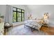 Bright bedroom with a large window offering natural light and backyard views, complemented by tasteful decor and hardwood floors at 1188 Woodtrace Ln, Auburn, GA 30011
