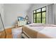 Bright bedroom with a large window offering backyard views, hardwood floors, and tasteful decor at 1188 Woodtrace Ln, Auburn, GA 30011