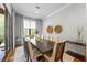 Elegant dining room with a dark wood table, seating for eight, and large windows overlooking a green forest at 1188 Woodtrace Ln, Auburn, GA 30011