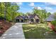 Charming brick home with a well-manicured lawn and long driveway leading to a three-car garage at 1188 Woodtrace Ln, Auburn, GA 30011
