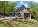 Brick home featuring a well-kept lawn, complemented by trimmed bushes and a three-car garage at 1188 Woodtrace Ln, Auburn, GA 30011