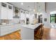 Bright kitchen features white cabinets, a patterned backsplash, stainless steel appliances, and a large island with seating at 1188 Woodtrace Ln, Auburn, GA 30011