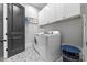 Well-organized laundry room featuring tile flooring, white cabinets, and modern washer and dryer at 1188 Woodtrace Ln, Auburn, GA 30011
