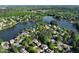Wide aerial view of neighborhood homes, roads, and a lake surrounded by lush trees at 1315 Badingham Dr, Cumming, GA 30041