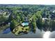 An aerial view shows a luxury house with large pool and gazebo in a lakeside wooded community at 1315 Badingham Dr, Cumming, GA 30041