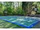 A private outdoor basketball court is surrounded by shade trees and open sky at 1315 Badingham Dr, Cumming, GA 30041