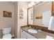 Bathroom with granite countertops, brushed metal fixtures, framed mirror, and cream-colored walls at 1315 Badingham Dr, Cumming, GA 30041