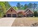 Charming brick home with a well-maintained lawn, mature landscaping, and a two-car garage at 1315 Badingham Dr, Cumming, GA 30041