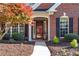 Inviting front entrance with a red door, manicured landscaping, and brick facade at 1315 Badingham Dr, Cumming, GA 30041