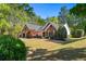 Lovely brick home with black shutters, a two-car garage, and a well-maintained front lawn at 1315 Badingham Dr, Cumming, GA 30041