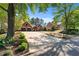 Landscaped front yard with mature trees leading up to a brick home with a two-car garage at 1315 Badingham Dr, Cumming, GA 30041