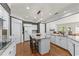 Bright, spacious kitchen features white cabinetry, granite countertops, island and wood floors at 1315 Badingham Dr, Cumming, GA 30041