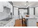 Bright kitchen features white cabinetry, granite countertops, center island with seating and modern appliances at 1315 Badingham Dr, Cumming, GA 30041