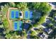 An aerial view of tennis courts and a basketball court, nestled in a wooded community near the lake at 1315 Badingham Dr, Cumming, GA 30041