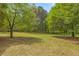 Expansive backyard featuring mature trees and a well-maintained lawn at 928 Rocky Creek Rd, Hampton, GA 30228