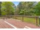 Wooden deck with railing overlooking a large yard with trees at 928 Rocky Creek Rd, Hampton, GA 30228
