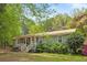 Charming home exterior showcasing the front porch, metal roof, light-colored siding, and natural landscaping at 928 Rocky Creek Rd, Hampton, GA 30228