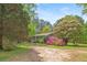 Charming single-story home with a covered porch, surrounded by lush landscaping and mature trees at 928 Rocky Creek Rd, Hampton, GA 30228