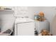 Bright laundry room features a washing machine, storage shelves and a chest freezer at 928 Rocky Creek Rd, Hampton, GA 30228