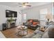 Living area featuring hardwood floors, ample seating, a ceiling fan, and a decorative fireplace at 928 Rocky Creek Rd, Hampton, GA 30228