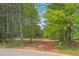 View of the property's entrance, showcasing its wooded surroundings and a gravel driveway leading to the home at 928 Rocky Creek Rd, Hampton, GA 30228