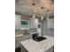 Well-lit kitchen features white cabinets, modern lighting, stainless steel appliances, and a center island with gas cooktop at 169 Long Dr, Marietta, GA 30060