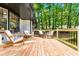 Spacious front deck features comfortable seating, perfect for relaxing and enjoying the serene wooded views at 2152 Tourney Dr, Marietta, GA 30062