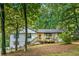 Inviting white home with black trim features a cozy front porch and wooded views at 2152 Tourney Dr, Marietta, GA 30062