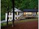 Attractive white home with black trim has a welcoming front porch and well-maintained landscaping at 2152 Tourney Dr, Marietta, GA 30062