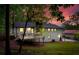 Backyard view showcases the home's rear deck, grassy lawn, and wooded surroundings at twilight at 2152 Tourney Dr, Marietta, GA 30062