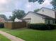 A single-story home with muted blue shutters is sided with unpainted clapboards and a fenced front yard at 2617 Terrace Pkwy, Morrow, GA 30260