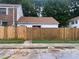 A single-story home with a brown roof is protected by a new wooden fence at 2617 Terrace Pkwy, Morrow, GA 30260