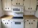 An outdated kitchen features white cabinets, appliances, and laminate countertops at 2617 Terrace Pkwy, Morrow, GA 30260