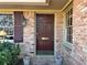 Inviting brick home entrance featuring a classic wood door and decorative window shutters at 3358 Stonecrest Ct, Atlanta, GA 30341