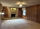 This is a large living room area, featuring a stone fireplace, wood paneling, and a window at 3358 Stonecrest Ct, Atlanta, GA 30341