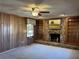 Cozy living room features wood paneling, a stone fireplace with built-in shelving, and a ceiling fan at 3358 Stonecrest Ct, Atlanta, GA 30341