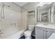 Clean bathroom featuring a bathtub, toilet, sink, gray vanity, and blue tiled floors at 706 Cather Ct, Stone Mountain, GA 30088