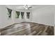 Large, light-filled bedroom featuring modern wood floors, three windows, ceiling fan and neutral walls at 706 Cather Ct, Stone Mountain, GA 30088