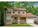 Charming two-story home with a cozy front porch and attached garage, nestled among lush greenery at 706 Cather Ct, Stone Mountain, GA 30088