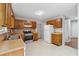 Kitchen with wooden cabinets, white appliances, and a bright overhead light at 706 Cather Ct, Stone Mountain, GA 30088