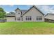Back of house featuring neutral siding, multiple windows, and a large grassy yard at 4512 Evan Ct, Hoschton, GA 30548