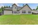 Back of house featuring neutral siding, multiple windows, and a large grassy yard at 4512 Evan Ct, Hoschton, GA 30548